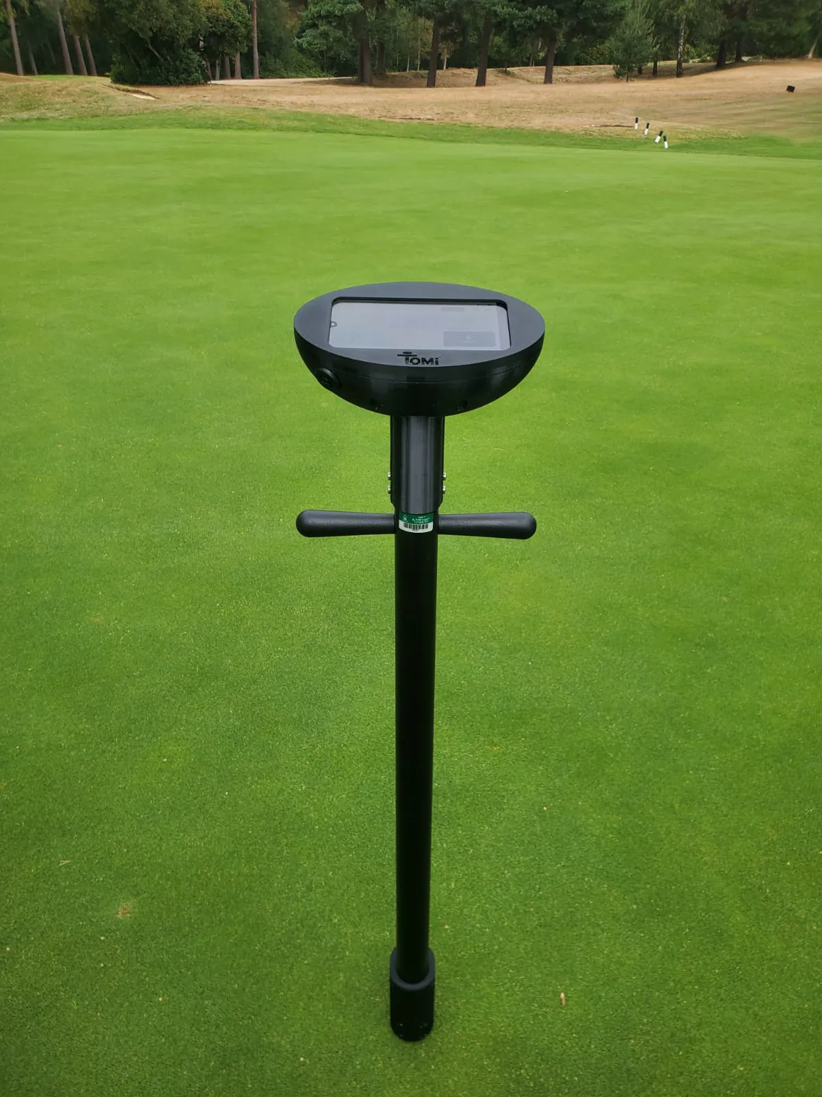 Close-up of the TOMi instrument head resting on a closely mown green